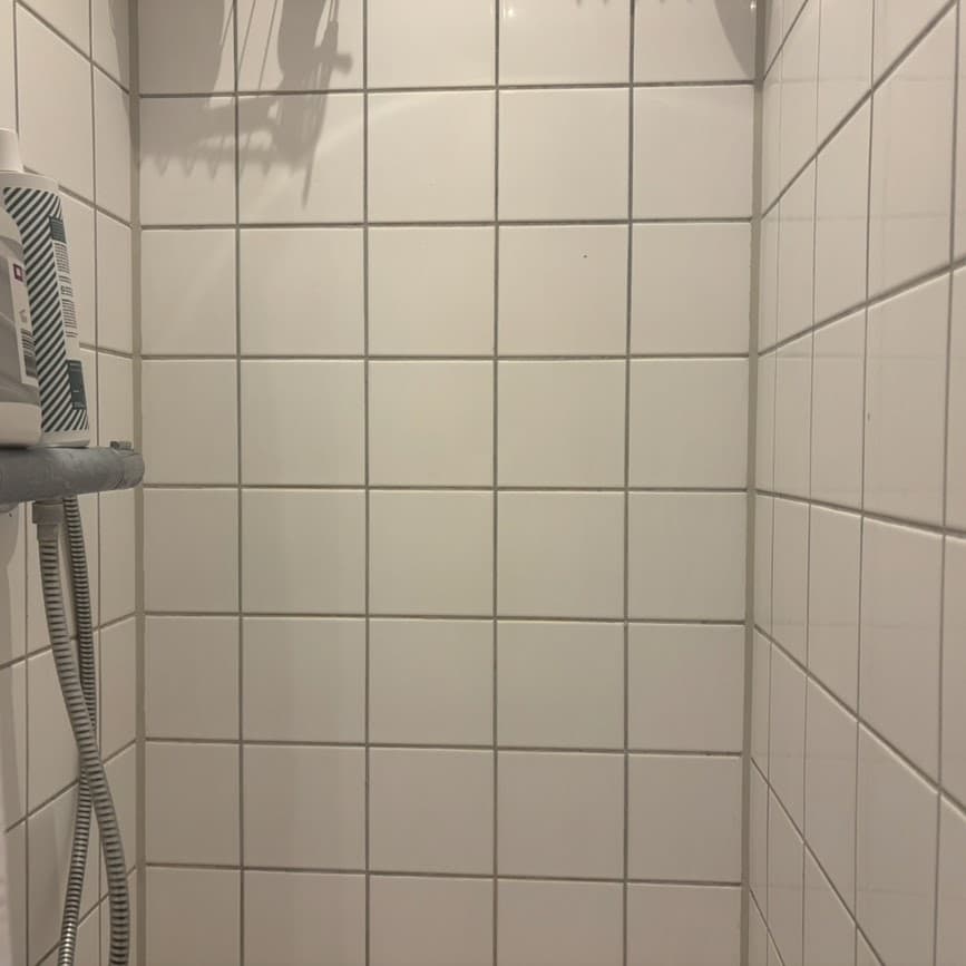 Nyfuget badeværelse med rene fuger langs fliserne
